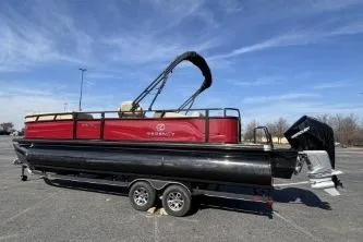 Slide: The Image of 2025 Regency 250 DL3 pontoon boat on trailer under clear blue sky. - 2