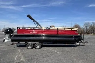 Slide: The Image of 2025 Regency 250 DL3 pontoon boat on trailer under clear blue sky. - 3
