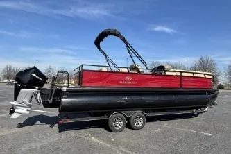 Slide: The Image of 2025 Regency 250 DL3 pontoon boat with red and black design, parked outdoors. - 4