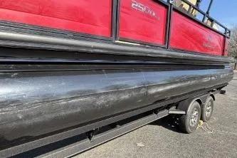 Slide: The Image of 2025 Regency 250 DL3 pontoon boat on trailer, featuring red and black design. - 8