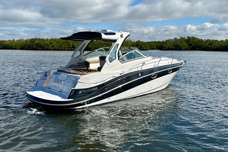 Slide: The Image of 2016 Four Winns V335 boat cruising on a calm lake under a cloudy sky. - 1