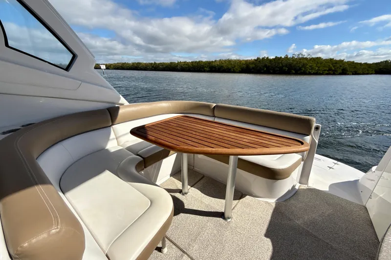 Slide: The Image of 2016 Four Winns V335 yacht with elegant seating and wooden table on deck. - 11