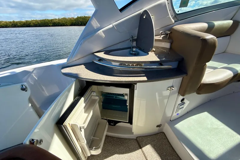 Slide: The Image of 2016 Four Winns V335 boat interior with open mini fridge and sink. - 15