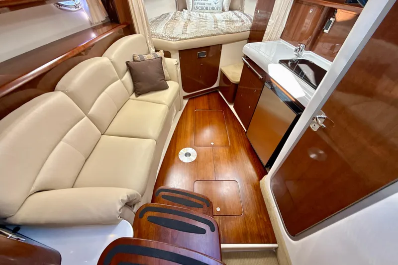 Slide: The Image of Luxurious 2016 Four Winns V335 yacht interior with beige seating and compact kitchen area. - 18