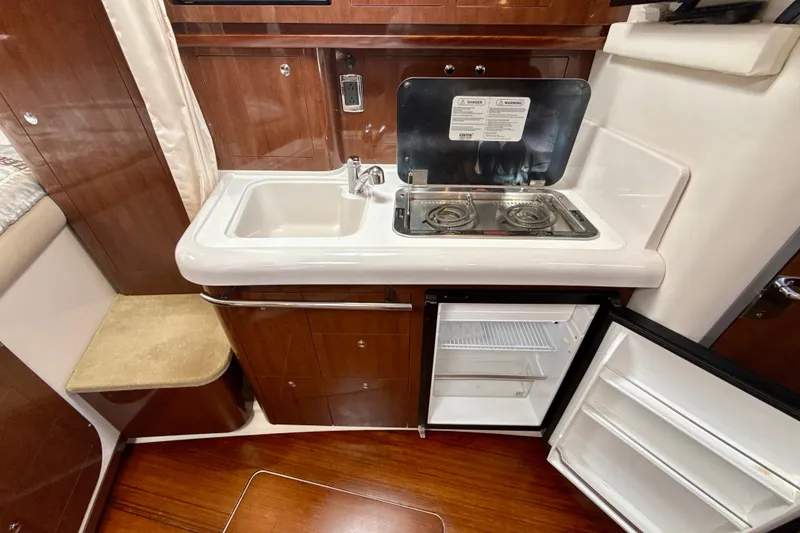 Slide: The Image of Compact kitchen area in 2016 Four Winns V335 boat with sink, stove, and fridge. - 22