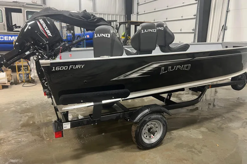 Slide: The Image of 2026 Lund 1600 Fury Tiller boat with Mercury engine in a garage setting. - 3