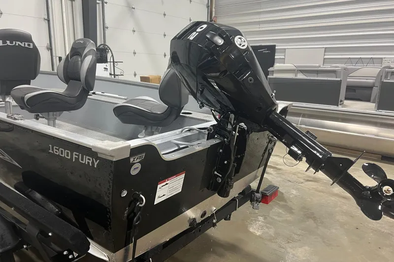 Slide: The Image of 2026 Lund 1600 Fury Tiller boat with motor in a showroom. - 8