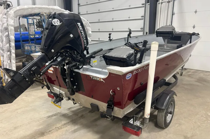 Slide: The Image of 2019 Lund 1600 Fury Tiller boat with Mercury outboard motor in a garage. - 5