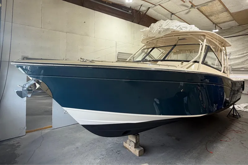 The Image of 2015 Grady-White Freedom 307 boat in indoor storage, blue hull, white top. - 0