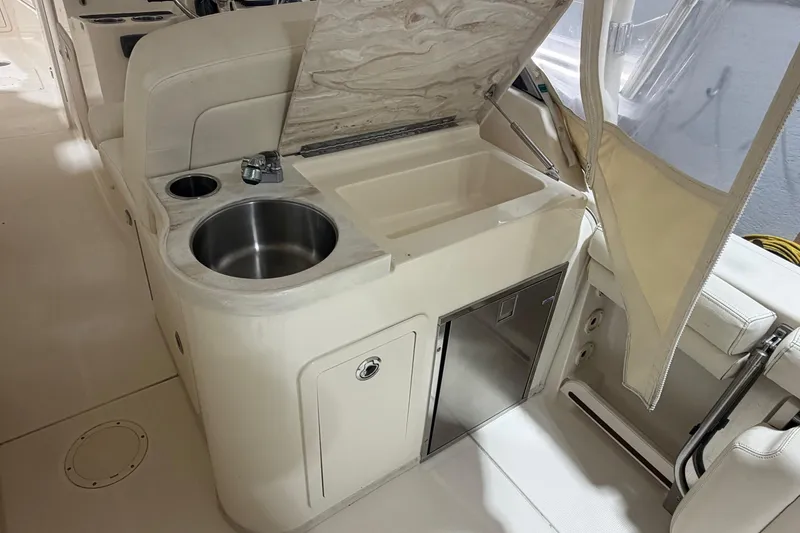 Slide: The Image of 2015 Grady-White Freedom 307 boat interior with sink and storage area. - 10