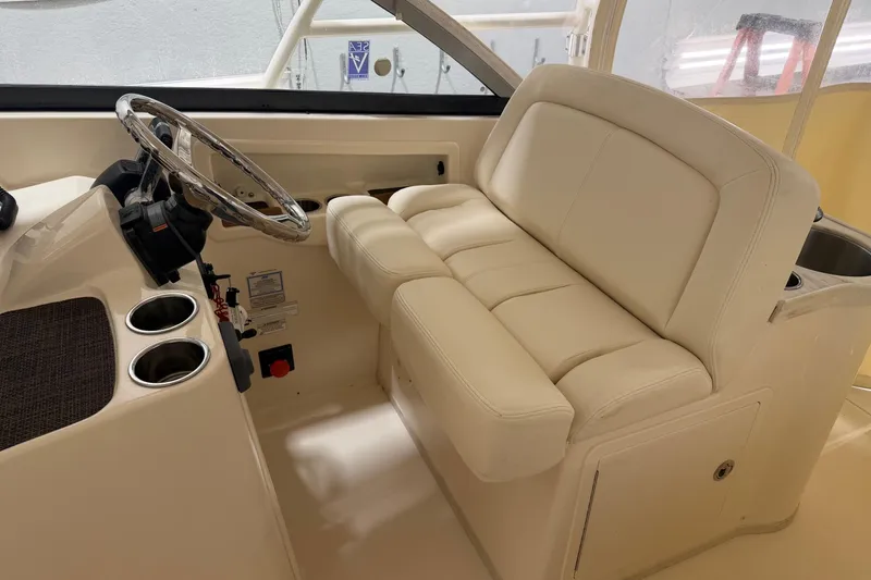 Slide: The Image of 2015 Grady-White Freedom 307 boat interior with steering wheel and cushioned seating. - 4