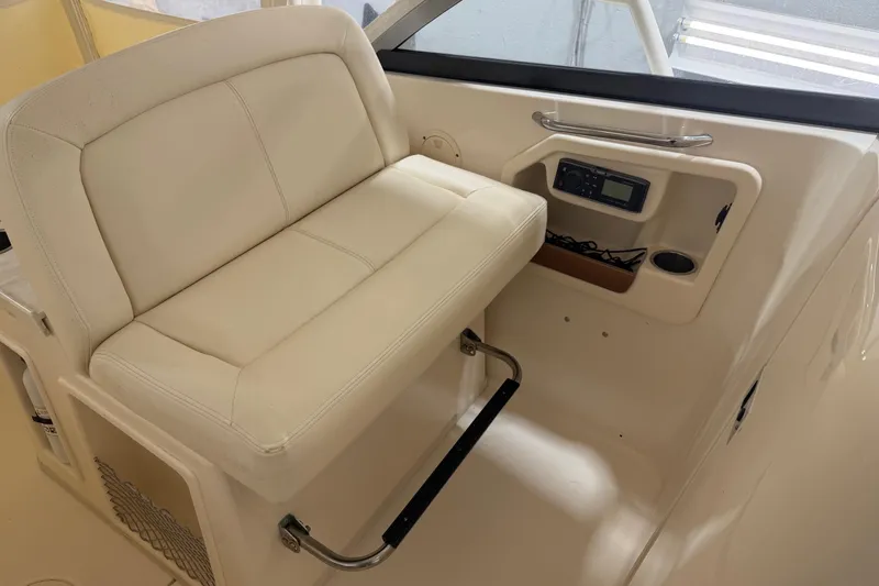 Slide: The Image of 2015 Grady-White Freedom 307 boat interior with cushioned seating and control panel. - 5