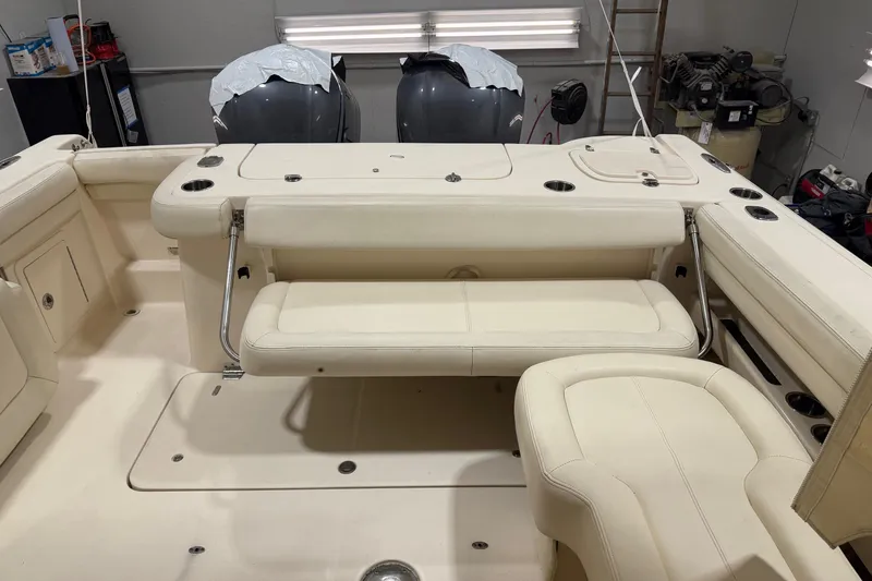 Slide: The Image of 2015 Grady-White Freedom 307 boat interior with seating and dual engines in a garage. - 8