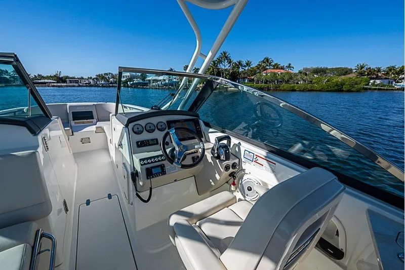 Slide: The Image of 2019 Boston Whaler 270 Vantage boat interior with steering wheel and dashboard, on a sunny day. - 10