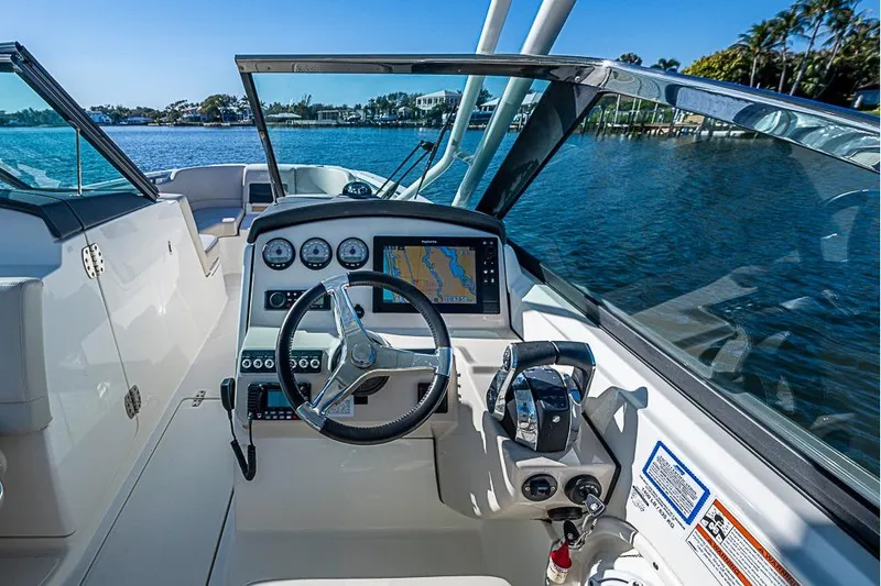 Slide: The Image of 2019 Boston Whaler 270 Vantage boat cockpit with steering wheel and navigation system. - 11