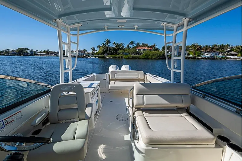 Slide: The Image of 2019 Boston Whaler 270 Vantage boat interior with seating, on a sunny day by the water. - 13