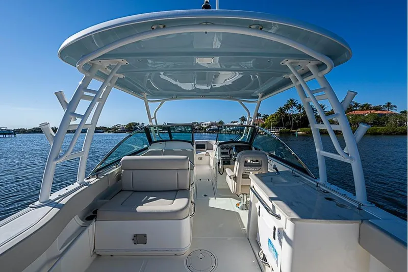 Slide: The Image of 2019 Boston Whaler 270 Vantage boat interior with seating and helm, on calm water. - 15