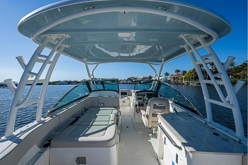 Slide: The Image of 2019 Boston Whaler 270 Vantage boat interior with seating and helm, on calm water. - 17