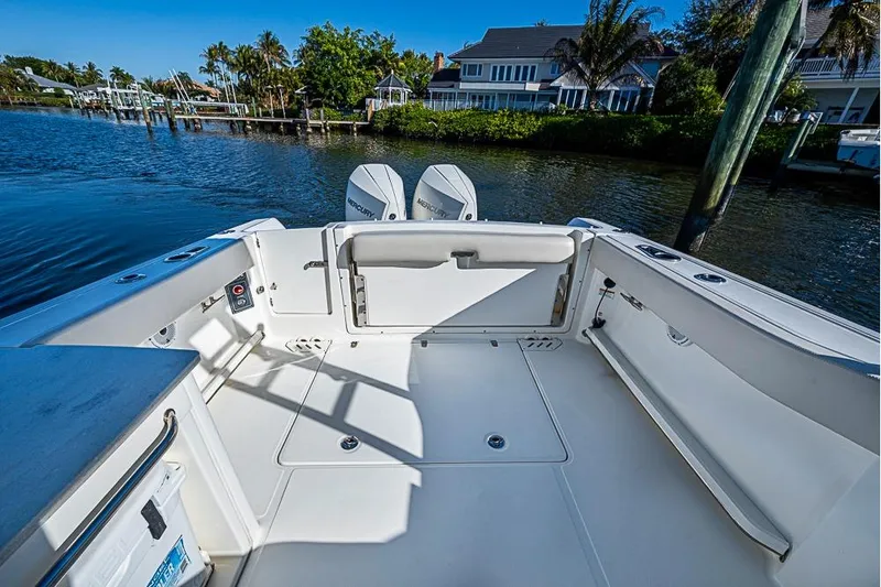 Slide: The Image of 2019 Boston Whaler 270 Vantage boat interior with dual Mercury engines, docked by waterfront homes. - 19