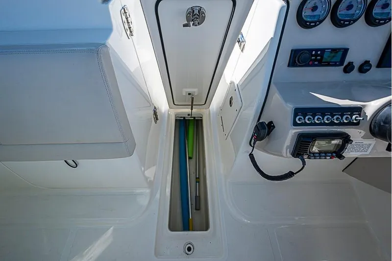 Slide: The Image of 2019 Boston Whaler 270 Vantage cockpit with storage compartment and control panel. - 7