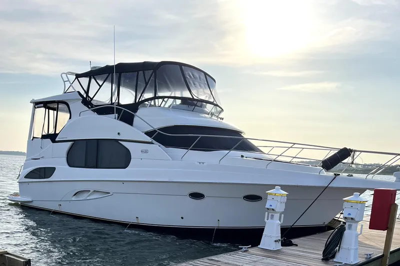 The Image of 2005 Silverton 43 Motor Yacht docked at sunset, featuring sleek design and spacious deck. - 0