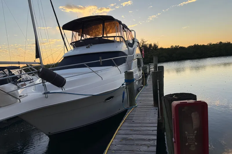 Slide: The Image of 2005 Silverton 43 Motor Yacht docked at sunset, serene waterfront view. - 1