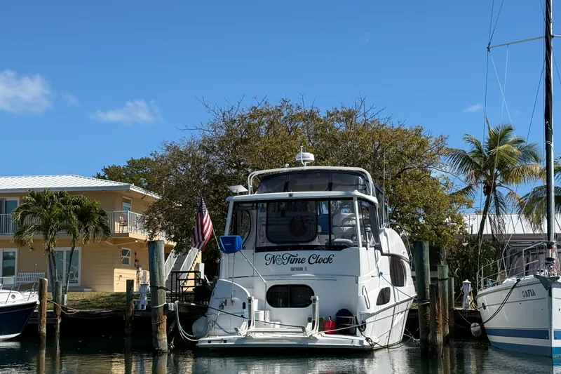 Slide: The Image of 2005 Silverton 43 Motor Yacht docked near palm trees and a house. - 2