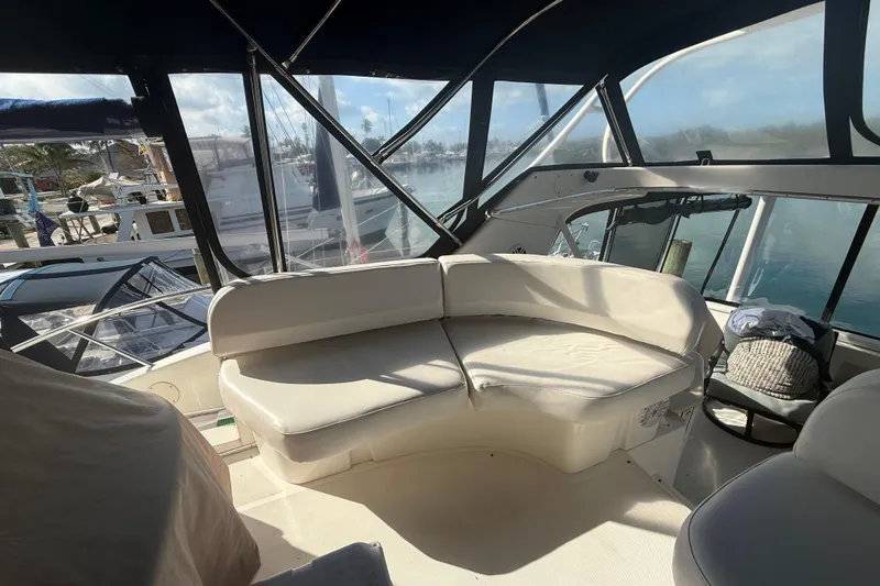 Slide: The Image of 2005 Silverton 43 Motor Yacht interior with white seating and marina view. - 20