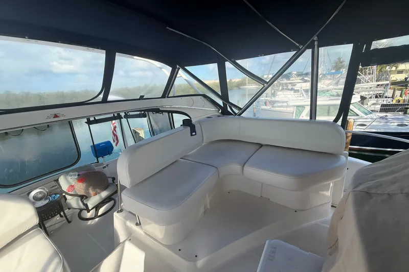 Slide: The Image of 2005 Silverton 43 Motor Yacht interior with white seating and marina view. - 22