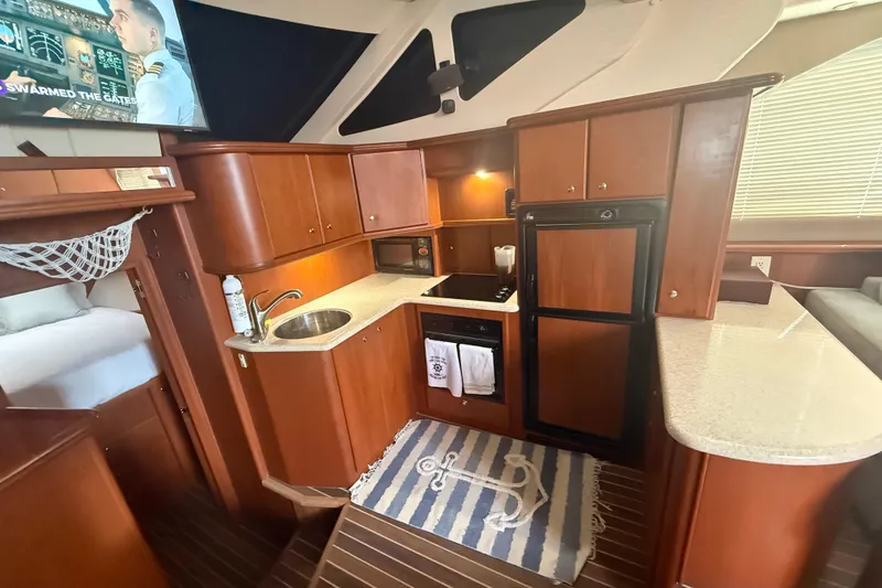 Slide: The Image of 2005 Silverton 43 Motor Yacht interior kitchen with wood cabinetry and modern appliances. - 7