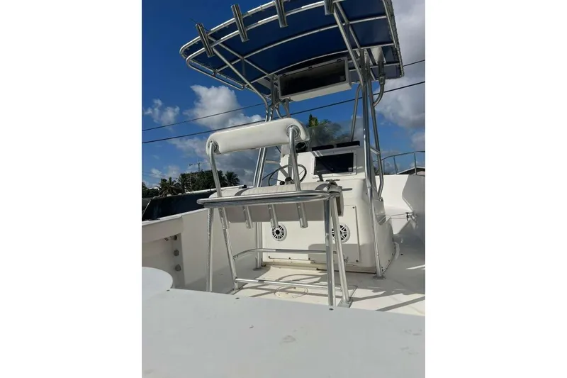 Slide: The Image of 1997 Cobia 244 Center Console boat with T-top under a clear blue sky. - 13