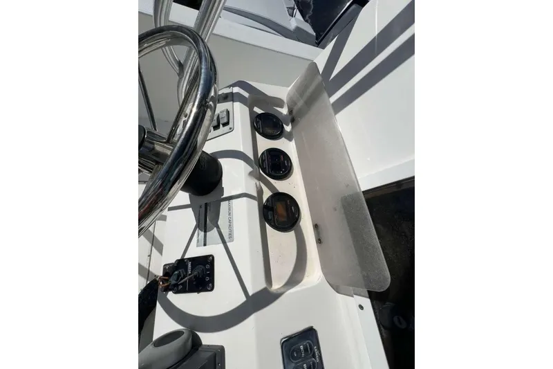 Slide: The Image of 1997 Cobia 244 Center Console boat dashboard with steering wheel and gauges. - 14