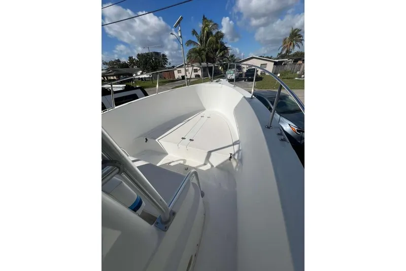 Slide: The Image of 1997 Cobia 244 Center Console boat with spacious deck, parked outdoors under blue sky. - 15