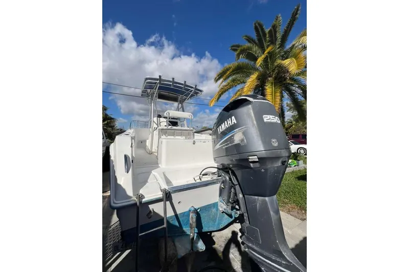 Slide: The Image of 1997 Cobia 244 Center Console boat with Yamaha 250 outboard motor, under clear blue sky. - 22
