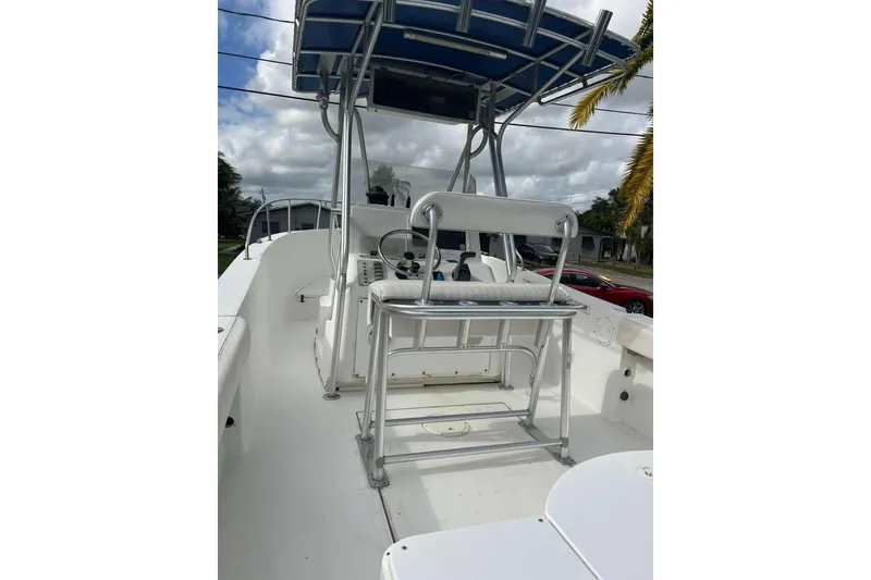 Slide: The Image of 1997 Cobia 244 Center Console boat with T-top and seating, under cloudy sky. - 7
