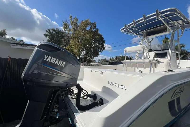 Slide: The Image of 1997 Cobia 244 Center Console boat with Yamaha outboard motor, under a clear blue sky. - 8