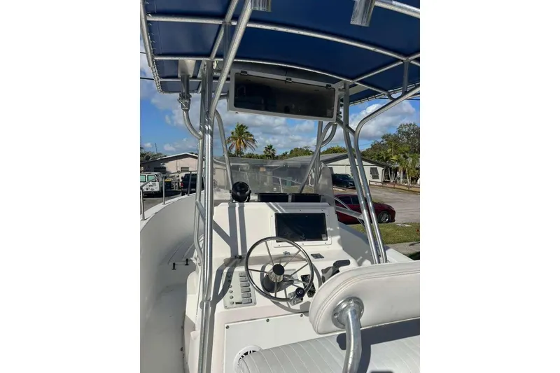 Slide: The Image of 1997 Cobia 244 Center Console boat with steering wheel and navigation equipment. - 9