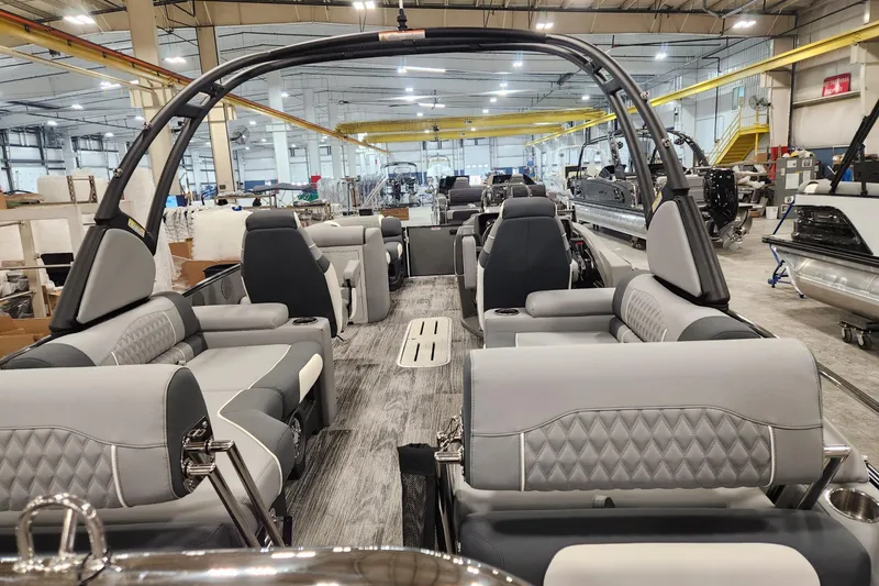 Slide: The Image of 2026 Avalon Catalina Quad Lounge Shift boat interior with luxurious seating in a spacious factory setting. - 2