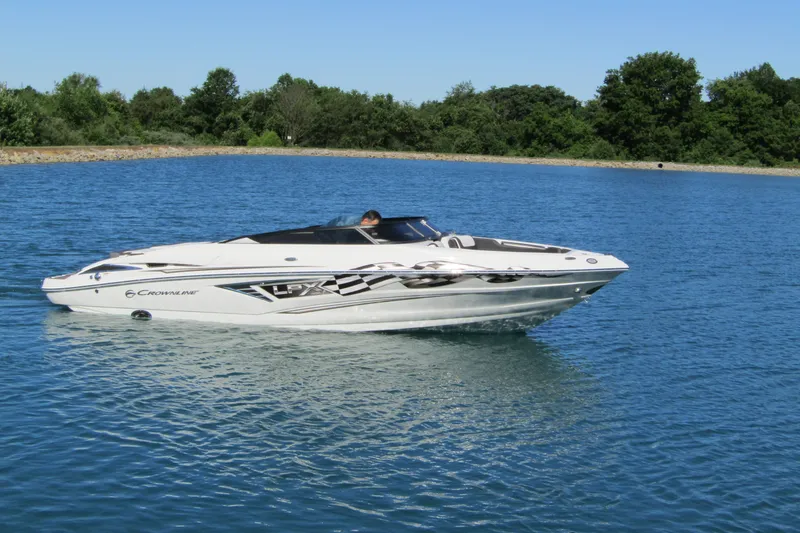 The Image of 2025 Crownline 220 SS LPX boat cruising on a serene lake. - 0