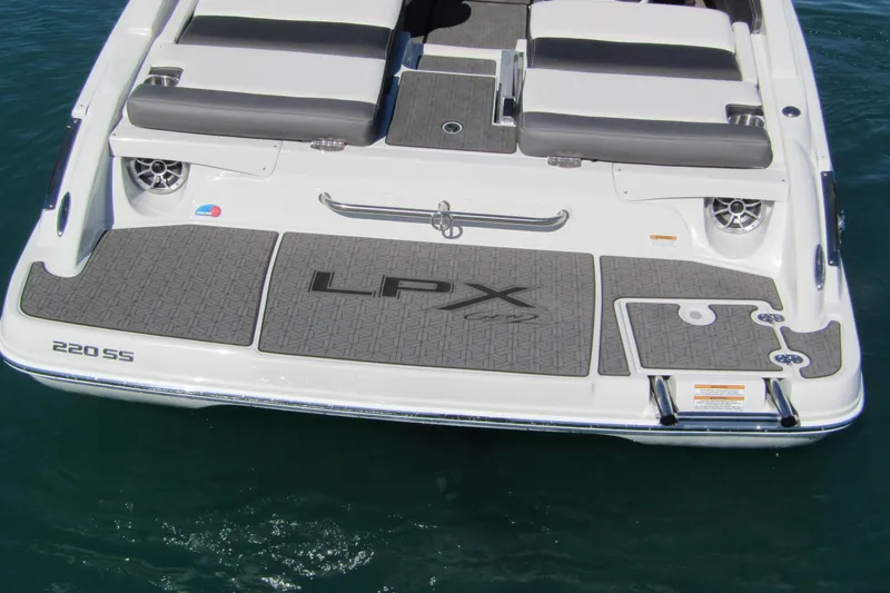 Slide: The Image of 2025 Crownline 220 SS LPX boat with sleek deck design on water. - 5