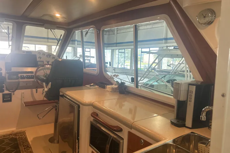 Slide: The Image of Interior of 2007 True North 38 Heritage boat with helm, kitchenette, and seating area. - 15