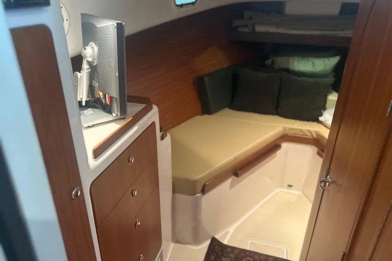 Slide: The Image of 2007 True North 38 Heritage cabin interior with bed, storage, and TV. - 26