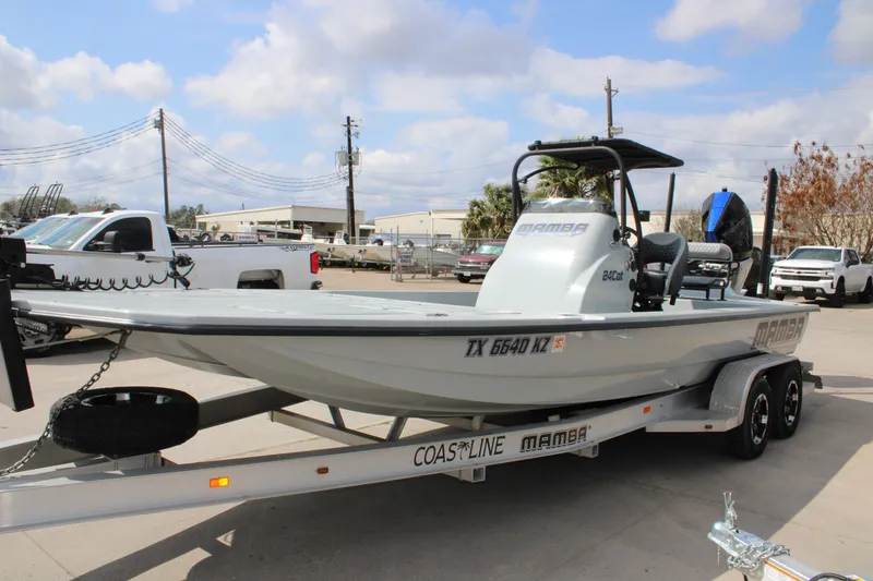Slide: The Image of 2025 Mamba 24 Cat Elite boat on trailer, parked outdoors under cloudy sky. - 3