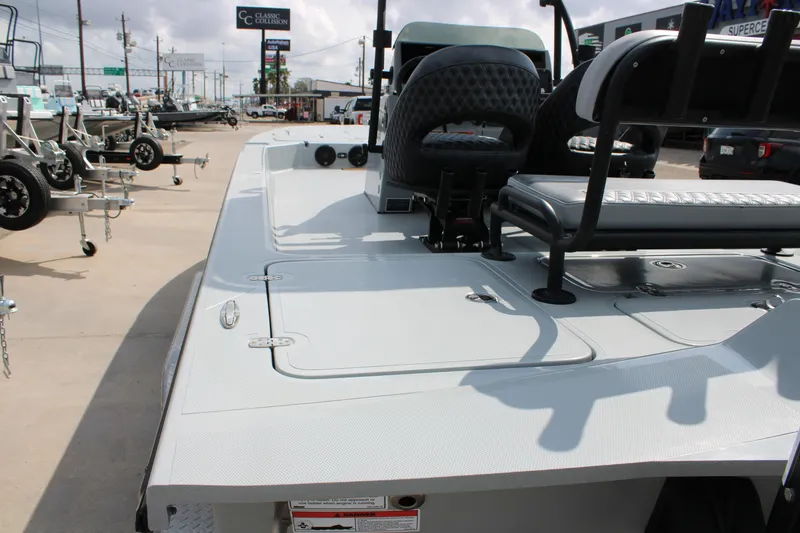 Slide: The Image of 2025 Mamba 24 Cat Elite boat interior with seating and storage, displayed outdoors. - 8