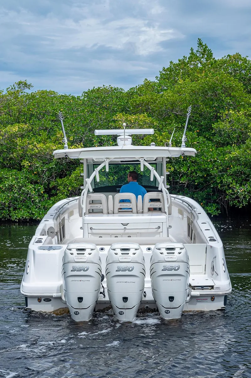 Slide: The Image of 2017 Boston Whaler 370 Outrage boat with triple engines on a calm waterway. - 19