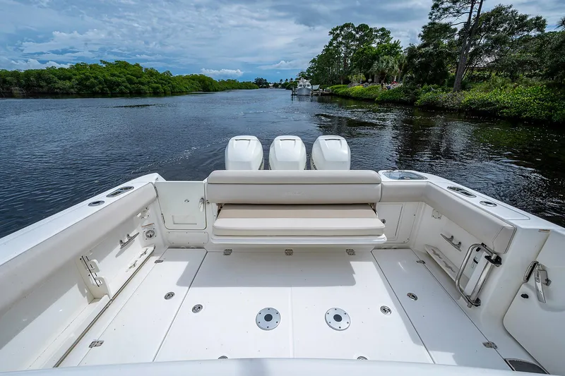 Slide: The Image of 2017 Boston Whaler 370 Outrage boat on a serene river with lush greenery. - 31