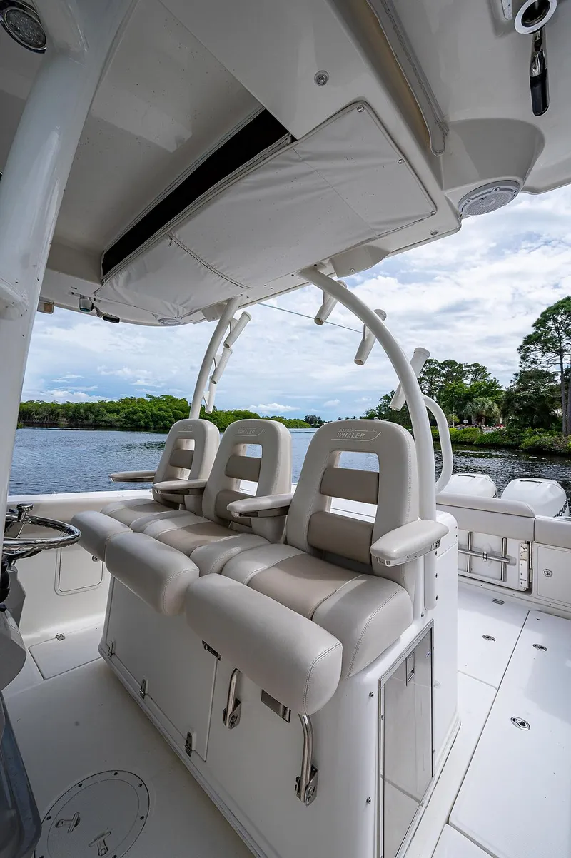 Slide: The Image of 2017 Boston Whaler 370 Outrage boat interior with cushioned seating and scenic water view. - 38