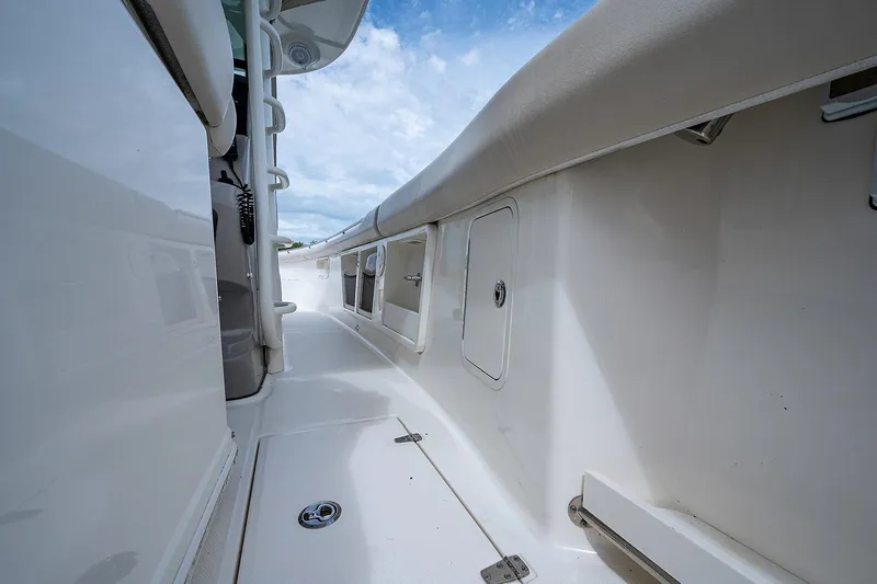 Slide: The Image of 2017 Boston Whaler 370 Outrage boat deck, featuring sleek white design and storage compartments. - 42