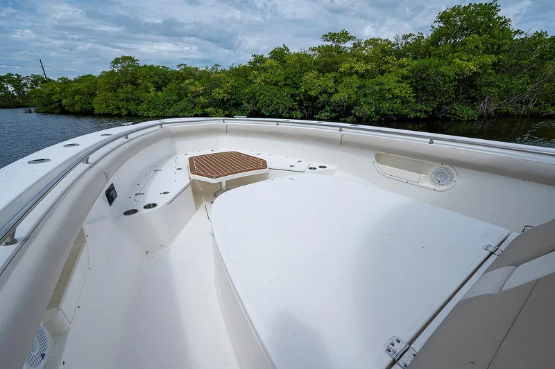 Slide: The Image of 2017 Boston Whaler 370 Outrage boat deck with lush greenery in the background. - 43