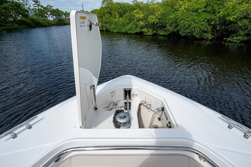 Slide: The Image of 2017 Boston Whaler 370 Outrage boat with open anchor locker on calm water. - 45